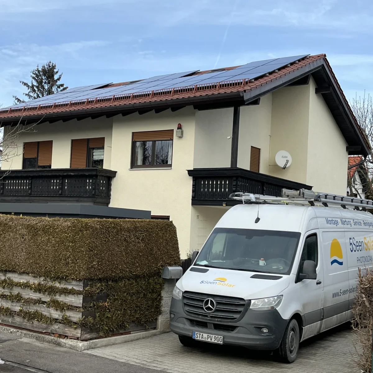Älteres Haus mit PV-Anlage. In der Einfahrt steht ein 5 Seen Solar Firmenfahrzeug